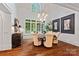 This dining room is bright with a large window, hardwood floors, and an ornate chandelier at 10300 Sweetleaf Pl, Charlotte, NC 28278
