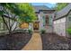 Charming stone home with arched windows, green shutters, and manicured front yard at 10300 Sweetleaf Pl, Charlotte, NC 28278