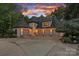 Spacious stucco home featuring a four-car garage and beautiful sunset views at 10300 Sweetleaf Pl, Charlotte, NC 28278