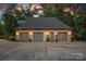Detached three-car garage with ample driveway space and elegant exterior lighting at 10300 Sweetleaf Pl, Charlotte, NC 28278