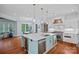 Open concept kitchen with hardwood floors, white cabinets, and stainless appliances at 10300 Sweetleaf Pl, Charlotte, NC 28278