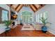 Living room showcasing a vaulted ceiling, stone fireplace, and large windows with plantation shutters at 10300 Sweetleaf Pl, Charlotte, NC 28278