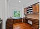 Charming office with a built-in desk, shelving, window seat, and wood floors at 10300 Sweetleaf Pl, Charlotte, NC 28278