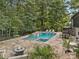 Backyard pool and spa area with a fire pit, lounge chairs, and stone pavers at 10300 Sweetleaf Pl, Charlotte, NC 28278