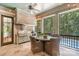 Screened outdoor kitchen featuring a built-in grill, dining area, and wooded views at 10300 Sweetleaf Pl, Charlotte, NC 28278