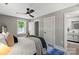 Stylish bedroom with ceiling fan, open door to bathroom, and natural light at 1055 Laurel Ave, Lancaster, SC 29720