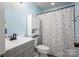 Bright bathroom featuring a polka dot shower curtain, grey vanity, and toilet at 107 Ingonish Dr, Gastonia, NC 28056