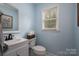 Charming bathroom with a vanity and mirror, featuring a toilet and a window providing natural light at 107 Ingonish Dr, Gastonia, NC 28056