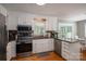 Bright kitchen with white cabinets, stainless steel appliances, granite counters, and hardwood floors at 107 Ingonish Dr, Gastonia, NC 28056