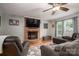 Relax in this living room featuring hardwood floors, a brick fireplace, and lots of natural light at 107 Ingonish Dr, Gastonia, NC 28056