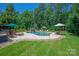 Luxurious backyard featuring a freeform pool, waterfall, and mature trees at 1085 Wessington Manor Ln, Fort Mill, SC 29715