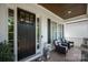 Inviting front porch featuring a dark front door, comfortable seating, and stylish accents, creating a welcoming entrance at 1085 Wessington Manor Ln, Fort Mill, SC 29715
