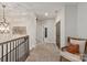 Upstairs hallway with neutral carpet, wood banister, chair, and a modern light fixture at 1085 Wessington Manor Ln, Fort Mill, SC 29715