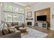 Bright living room with floor-to-ceiling windows, fireplace, wood accent wall, and a comfortable sectional sofa at 1085 Wessington Manor Ln, Fort Mill, SC 29715
