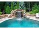 Close-up of a stunning rock waterfall cascading into a beautifully designed swimming pool at 1085 Wessington Manor Ln, Fort Mill, SC 29715