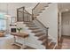 Elegant staircase with dark metal spindles, wood banister, and hardwood treads at 1085 Wessington Manor Ln, Fort Mill, SC 29715