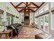 Inviting sunroom boasts beamed ceilings, a stone fireplace, and backyard views at 1085 Wessington Manor Ln, Fort Mill, SC 29715