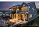 Back exterior with a patio, stone fireplace, outdoor dining, and a covered balcony at 11024 Shreveport Dr, Huntersville, NC 28078
