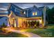 Attractive two-story house with a stone front, complemented by landscape lighting and a beautiful walkway at twilight at 11024 Shreveport Dr, Huntersville, NC 28078