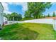 Backyard featuring lush green lawn, white fence, a patio area, and mature trees at 113 Summerhill Dr, Mooresville, NC 28115