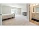 Bedroom featuring a large window, neutral carpet, and an ensuite bathroom; natural light at 113 Summerhill Dr, Mooresville, NC 28115