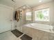 Luxurious main bathroom features a glass shower, soaking tub, and elegant marble tile at 113 Summerhill Dr, Mooresville, NC 28115