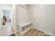 Bright mudroom features wood-look floors, built-in storage and bench, plus coat hooks by the door at 113 Summerhill Dr, Mooresville, NC 28115