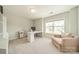 Bright home office with a white desk, shelving unit, and comfortable lounge chair near a window at 113 Summerhill Dr, Mooresville, NC 28115