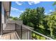 This deck features iron railings, a beautiful view of mature trees, and abundant natural light at 1160 S Kings Dr, Charlotte, NC 28207