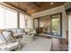Relaxing covered porch with wood ceiling, ceiling fan, and comfortable seating area at 1160 S Kings Dr, Charlotte, NC 28207