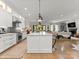 Bright, open kitchen featuring white cabinets, marble countertops, and an island with pendant lighting at 1160 S Kings Dr, Charlotte, NC 28207