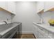 This bright laundry room features white cabinets, stone countertops, and modern appliances at 1160 S Kings Dr, Charlotte, NC 28207