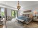 Bright main bedroom features a walkout balcony, shiplap wall, chandelier, and neutral color palette at 1160 S Kings Dr, Charlotte, NC 28207
