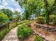 Landscaped backyard with black fencing, brick retaining walls, and a shed at 1209 S South St, Gastonia, NC 28052