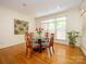 Bright dining area with hardwood floors, a window with blinds, an accent wall art, and a table with four chairs at 1209 S South St, Gastonia, NC 28052