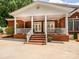 Brick home featuring a welcoming front porch with brick stairs and white columns at 1209 S South St, Gastonia, NC 28052