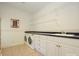 Well-equipped laundry room with washer, dryer, shelving and built-in cabinets offers ample storage at 1209 S South St, Gastonia, NC 28052