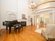 Spacious living room featuring hardwood floors, a piano, fireplace, and second story balcony at 1209 S South St, Gastonia, NC 28052