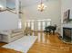 Open-concept living room with hardwood floors, a fireplace, high ceilings, and neutral decor at 1209 S South St, Gastonia, NC 28052