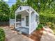 Charming shed with a porch is nestled in a landscaped backyard with brick pathway at 1209 S South St, Gastonia, NC 28052