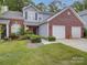 Charming home showcasing a well-manicured lawn and attached two-car garage at 12231 Stratfield Place Cir, Pineville, NC 28134