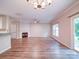 Bright open-concept living room with a fireplace, luxury vinyl plank floors, and a modern light fixture at 12231 Stratfield Place Cir, Pineville, NC 28134