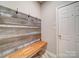 Welcoming mudroom features a rustic wood accent wall with hooks, a built-in bench, and tiled flooring at 12231 Stratfield Place Cir, Pineville, NC 28134