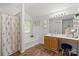 Bathroom boasts tub-shower, vanity with makeup area, and decorative mirror at 1410 Swaying Branch Ln, Clover, SC 29710