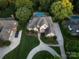 Aerial view of a distinguished brick home with lush landscaping, circular driveway, and a sparkling swimming pool at 1509 Churchill Downs Dr, Waxhaw, NC 28173