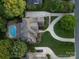 Aerial view showcasing a meticulously landscaped property with a swimming pool, circular driveway, and surrounding trees at 1509 Churchill Downs Dr, Waxhaw, NC 28173
