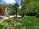 Backyard featuring a covered grill and a view of the pool and surrounding trees at 1509 Churchill Downs Dr, Waxhaw, NC 28173