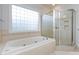 Clean bathroom featuring a large soaking tub, separate glass shower, and a window with privacy blocks at 1509 Churchill Downs Dr, Waxhaw, NC 28173