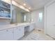 Bright bathroom with double sinks, white cabinets, large mirror, and a window bringing in natural light at 1509 Churchill Downs Dr, Waxhaw, NC 28173