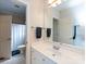 Bright, clean bathroom with white vanity, large mirror, and a shower with a white curtain at 1509 Churchill Downs Dr, Waxhaw, NC 28173